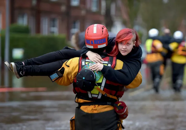 A member of the rescue team carries a young woman to safety through the flood water as they continue to to evacuate homes after Storm Desmond caused flooding on December 7, 2015 in Carlisle, England. Storm Desmond has brought severe disruption to areas of northern England with dozens of flood warnings remaining in place throughout the country. (Photo by Jeff J. Mitchell/Getty Images)