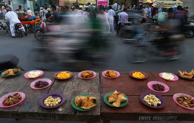 Free food is placed on tables at the road side as time to break the Fast approaches, during the holy Fasting month of Ramadan, in Karachi, Pakistan, 27 May 2018. Muslims around the world celebrate the holy month of Ramadan by praying during the night time and abstaining from eating, drinking, and sexual acts during the period between sunrise and sunset. Ramadan is the ninth month in the Islamic calendar and it is believed that the revelation of the first verse in Koran was during its last 10 nights. (Photo by Shahzaib Akber/EPA/EFE)