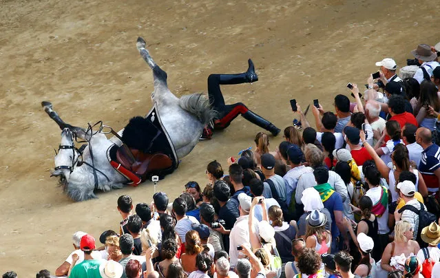 Italian Carabinieri police falls down from his horse during their parade prior the Palio of Siena horse race, Italy, July 2, 2018. (Photo by Stefano Rellandini/Reuters)