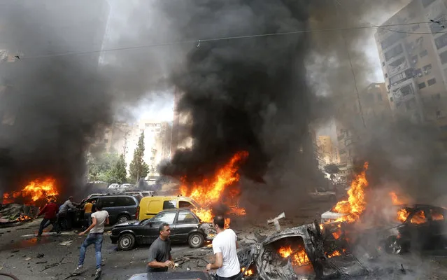 Civilians gather at the of an explosion in Beirut's southern suburb neighbourhood of Bir al-Abed on July 9, 2013.  A car bomb rocked Beirut's southern suburbs, stronghold of Lebanon's Shiite Hezbollah movement,  wounding 15 people, television reports and a military source said. (Photo by AFP Photo/STR)