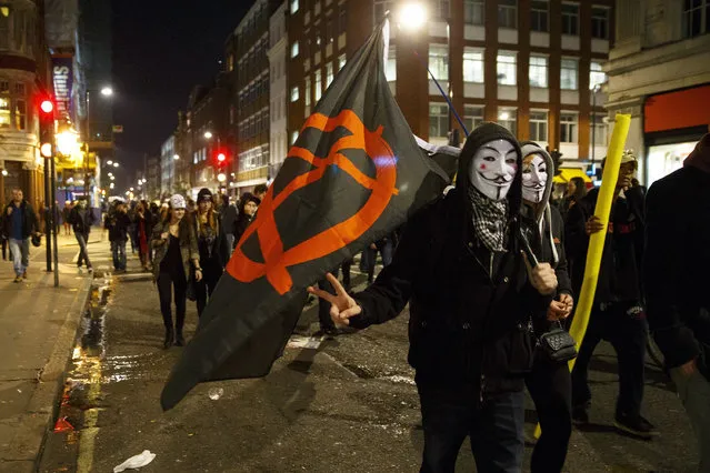 Masked protesters taking part at the 'Million Mask March' demonstration organised by activists Anonymous in London, England on November 5, 2014. The event has become associated with protesters donning the Guy Fawkes mask made famous by graphic novel and film of “V for Vendetta” and now used around the world as a symbol of anarchy. (Photo by Tolga Akmen/Anadolu Agency/Getty Images)