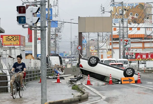 An overturned car is seen on a road following heavy rain in Ozu city, Ehime prefecture, southwestern Japan, Sunday, July 8, 2018. Heavy rainfall hammered southern Japan for the third day, prompting new disaster warnings on Kyushu and Shikoku islands on Sunday. (Photo by Michi Ono/Kyodo News via AP Photo)