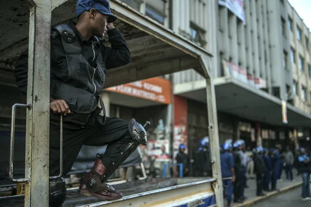 Riot police are seen in front of the opposition Movement for Democratic Change (MDC) headquarters in Harare, Thursday, August 2, 2018. MDC leader Nelson Chamisa says police have raided the headquarters and seized computers, while police say 18 people there were arrested. The developments come a few hours before the electoral commission is expected to start releasing the results of Monday's presidential election. (Photo by Mujahid Safodien/AP Photo)