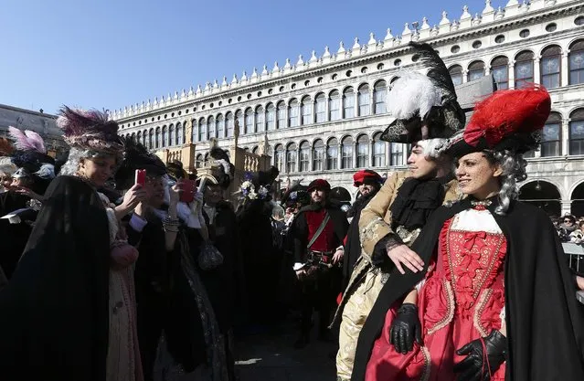 Masked revellers have their picture taken in Saint Mark Square during carnival in Venice February 8, 2015. (Photo by Stefano Rellandini/Reuters)