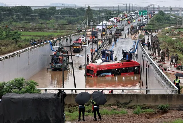 A bus is brought out of a flooded underground tunnel after flood water submerged 15 vehicles in the central town of Osong, South Korea, 16 July 2023. Seven people are confirmed to have been killed so far in the tunnel. (Photo by Yonhap/EPA)