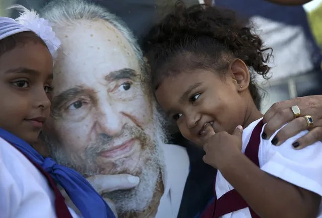 Marian Martin (L) and her sister Chanel pose next to a portrait of Cuba's late President Fidel Castro after paying tribute to Castro along with their mother at the Jose Marti Memorial in Revolution Square in Havana, Cuba, November 29, 2016. (Photo by Carlos Garcia Rawlins/Reuters)