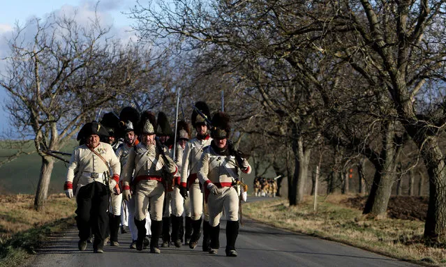 Historical re-enactment enthusiasts dressed as soldiers march ahead of a re-enactment of Napoleon's famous battle of Austerlitz, that will take place tomorrow, near the southern Moravian village of Herspice, Czech Republic December 2, 2016. (Photo by David W. Cerny/Reuters)