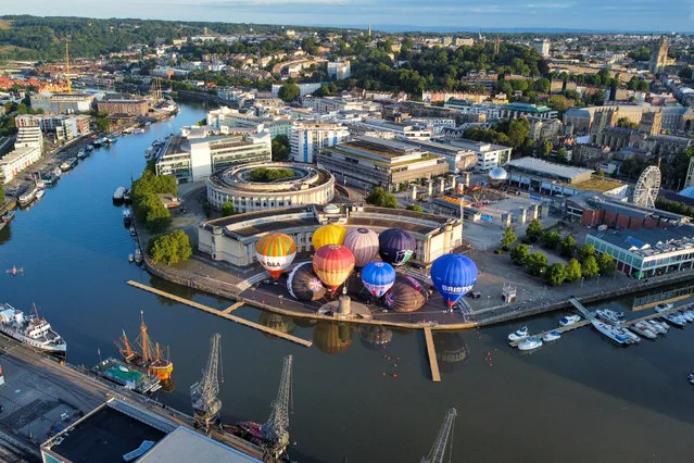 Hot air balloons inflate and tether from Bristol Harbourside in the early morning on Thursday, July 20, 2023 as the countdown begins to the 2023 Bristol International Balloon Fiesta at Ashton Court Estate in August. (Photo by Ben Birchall/PA Images via Getty Images)