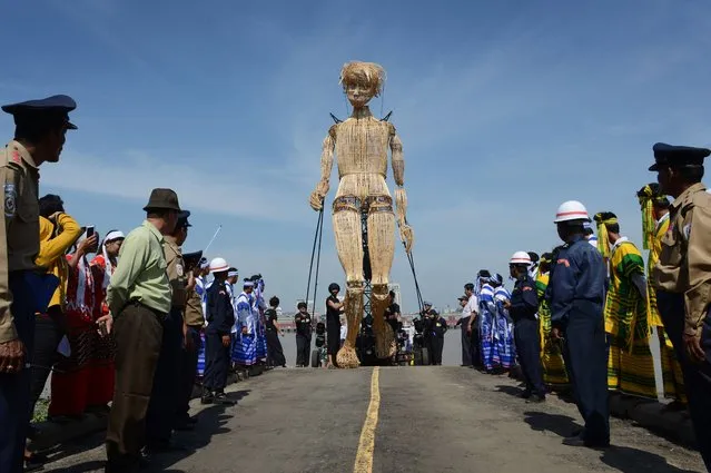 An eight-metre tall wicker puppet from the French cultural group L'Homme Debout arrives in Yangon city's Dala township for a parade on December 2, 2016 to mark the opening of the Mingalabar Festival. (Photo by Romeo Gacad/AFP Photo)