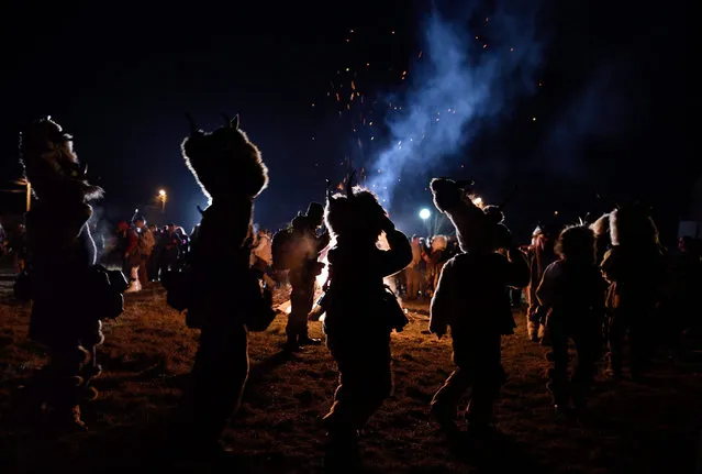 Bulgarian masked men 'Kuker' perform the traditional dance around a bonfire during the carnival in the village of Vatanovci, some 40 km from Sofia, Bulgaria  13 January 2016. This mask-dance 'Kuker' is a pre-Christian tradition of dancing to keep away the evil spirits. (Photo by Vassil Donev/EPA)