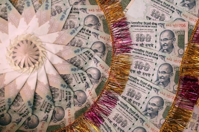 A garland made of Indian currency notes is pictured in a shop at a market in Jammu, India, November 13, 2016. (Photo by Mukesh Gupta/Reuters)