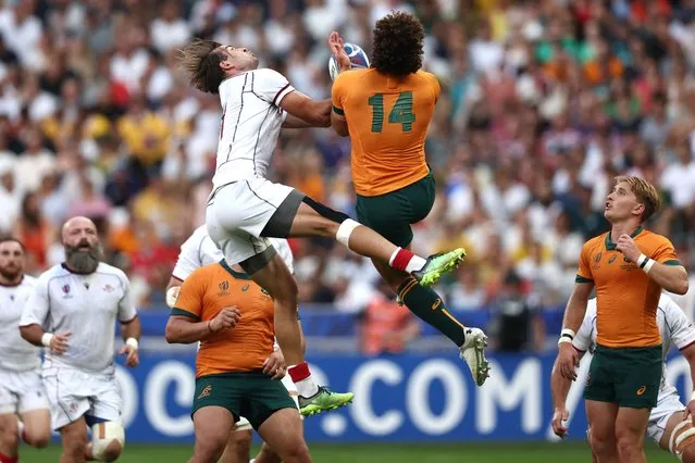 Georgia's left wing Mirian Modebadze (L) and Australia's right wing Mark Nawaqanitawase (R) jump for the ball  during the France 2023 Rugby World Cup Pool C match between Australia and Georgia at Stade de France in Saint-Denis, on the outskirts of Paris, on September 9, 2023. (Photo by Franck Fife/AFP Photo)