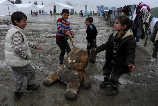 Refugee children play with a stuffed toy at a muddy makeshift camp at the Greek-Macedonian border, near the village of Idomeni, Greece March 15, 2016. (Photo by Alexandros Avramidis/Reuters)