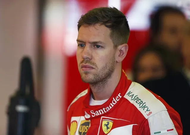 Ferrari Formula One driver Sebastian Vettel of Germany looks on in the team garage during the first practice session of the Australian F1 Grand Prix at the Albert Park circuit in Melbourne March 13, 2015. REUTERS/Brandon Malone