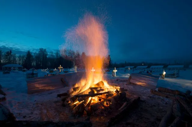 A fire burns as it thaws the frozen ground in order to dig a grave for one of the shooting victims at the cemetery in La Loche, Saskatchewan, Monday, January 25, 2016. A 17-year-old was charged with first-degree murder and attempted murder in a mass shooting at a school and home in the remote aboriginal community in western Canada on Friday, officials said. (Photo by Jonathan Hayward/The Canadian Press via AP Photo)