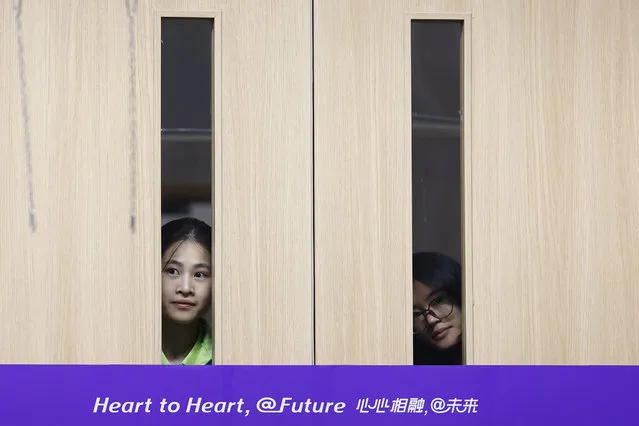 Volunteers watch the squash medal ceremony through the doors Asian Games at Hangzhou Olympic Sports Centre in Hangzhou, China on September 30, 2023. (Photo by Kim Kyung-Hoon/Reuters)