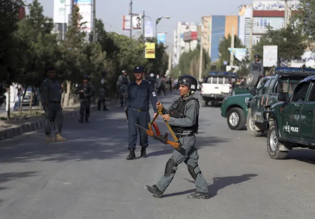 Security personnel arrive at the site of a deadly suicide bombing that targeted a training class in a private building in the Shiite neighborhood of Dasht-i Barcha, in western Kabul, Afghanistan, Wednesday, August 15, 2018. Both the resurgent Taliban and an Islamic State affiliate in Afghanistan have targeted Shiites in the past, considering them to be heretics. (Photo by Rahmat Gul/AP Photo)