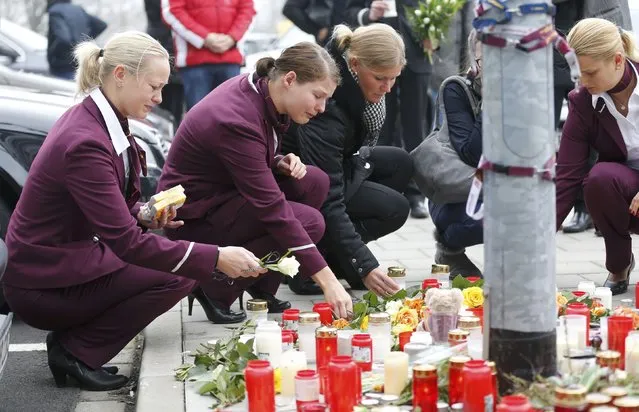 Germanwings employees cry as they place flowers and lit candles outside the company headquarters in Cologne Bonn airport March 25, 2015. (Photo by Wolfgang Rattay/Reuters)