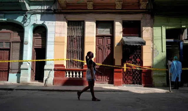 A woman walks past houses in quarantine amid concerns about the spread of the coronavirus disease (COVID-19), in Havana, Cuba, April 8, 2021. (Photo by Alexandre Meneghini/Reuters)