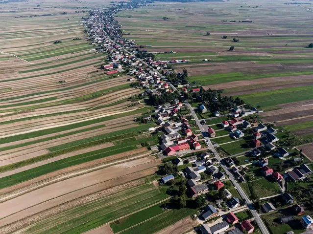 An aerial view of one of the longest streetscapes, a common name for villages where buildings are positioned directly on one street, in Suloszowa , Poland on September 29, 2023. The village of Suloszowa, with 6000 inhabitants, is considered of the longest villages in the Central European Country. The one single-street village has 9 km and due to the agricultural fields around it, has been denominated as Poland's Little Tuscany. (Photo by Omar Marques/Anadolu via Getty Images)