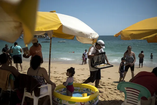 A man sells jewelry on the beach on April 1, 2015 in Acapulco, Mexico. Despite problems with cartel  violence Semana Santa is one of the biggest tourist weeks of the year in Acapulco, a city whose entire economy depends on tourism, and officials expect around 350,000 mostly Mexican visitors this week. (Photo by Jonathan Levinson/The Washington Post)