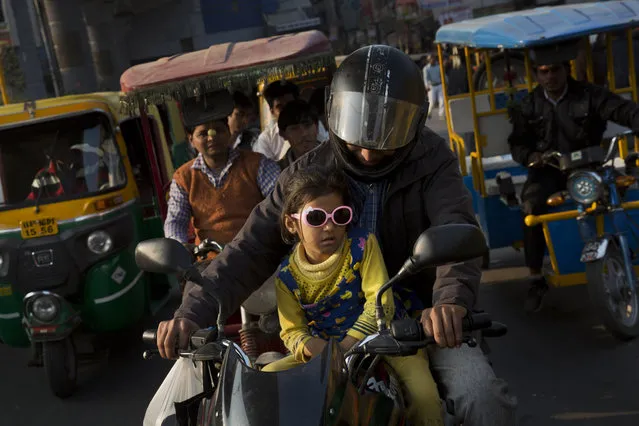 Motorbike and auto-rickshaw drivers make their way through a busy street in Noida, near New Delhi, India, Tuesday, February 9, 2016. (Photo by Bernat Armangue/AP Photo)