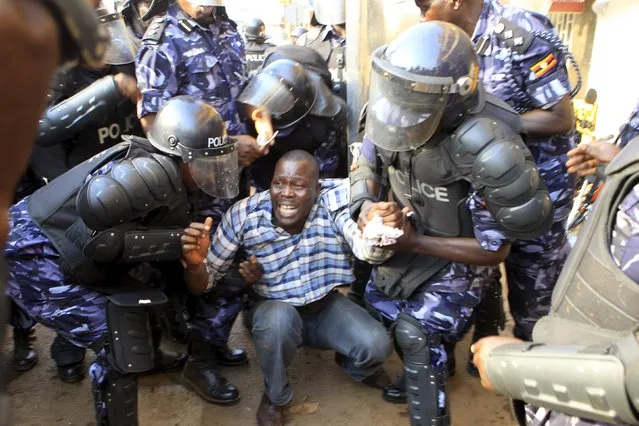 Riot police detain a supporter of Uganda's leading opposition party Forum for Democratic Change as police and military forces disperse their procession with their presidential candidate to a campaign ground in Kampala, Uganda, February 15, 2016. (Photo by James Akena/Reuters)