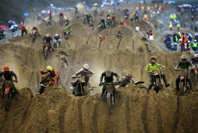 Riders reach the crest of a dune during the opening lap of the main race of the 2013 RHL Weston beach race in Weston-Super-Mare, southwest England, on October 13, 2013. (Photo by Adrian Dennis/AFP Photo)