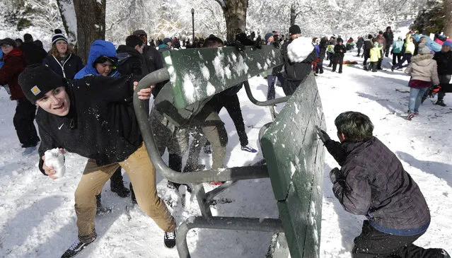 People taking part in a public snowball fight use a table as shield, Saturday, February 9, 2019, at Wright Park in Tacoma, Wash. (Photo by Ted S. Warren/AP Photo)