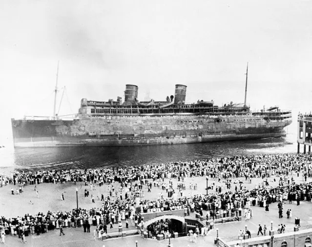 Thousands of people gather along the beach at Asbury Park, N.J., to view the smoldering U.S. steamship Morro Castle, September 9, 1934. The luxury liner, returning from Havana, Cuba, to New York City, caught fire off the New Jersey coast Sept. 8, killing 134 people.  The survivors were 119 crew and only 15 passengers. (Photo by AP Photo)