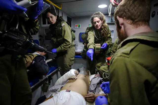 Israeli soldiers give initial medical treatment to wounded Syrians in an Israeli military ambulance, near the Syrian-Israeli border, in the Israeli-occupied Golan Heights January 18, 2017. (Photo by Baz Ratner/Reuters)
