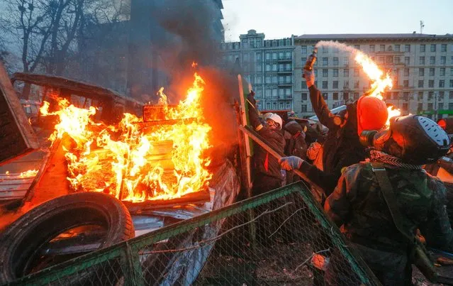 A protester throws a Molotov cocktail during an anti-government protest in downtown Kiev, Ukraine, on January 20th, 2014. (Photo by Sergey Dolzhenko/EPA)