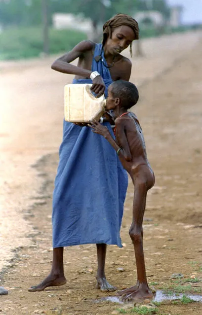 A starving Somali child is given water near a refugee camp in Baidoa, Somalia, December 14, 1992. (Photo by Yannis Behrakis/Reuters)