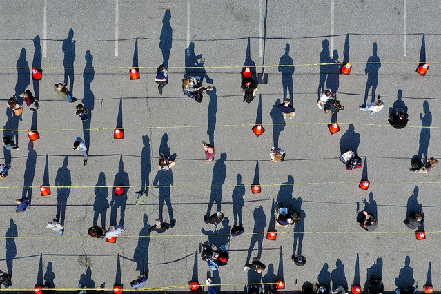 In an aerial view, some of the hundreds of people without appointments stand in line outside the mass coronavirus vaccination site at Hagerstown Premium Outlets on April 07, 2021 in Hagerstown, Maryland. The site opened to people without appointments Tuesday and, after waiting in line for hours, only 200 people without appointments were able to get vaccinated against COIVID-19. Site administrators hope to correct course Wednesday and serve more walk-ups. (Photo by Chip Somodevilla/Getty Images)