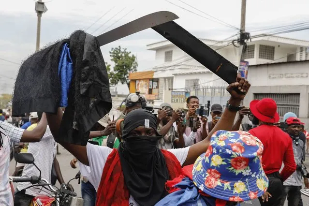 A masked protester wields a machete during a protest against Haitian Prime Minister Ariel Henry in Port-au-Prince, Haiti, Monday, February 5, 2024. (Photo by Odelyn Joseph/AP Photo)