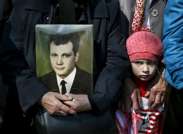 A woman holds a portrait of her relative, a victim of the Chernobyl nuclear disaster, during a ceremony in Kiev April 26, 2015. (Photo by Gleb Garanich/Reuters)