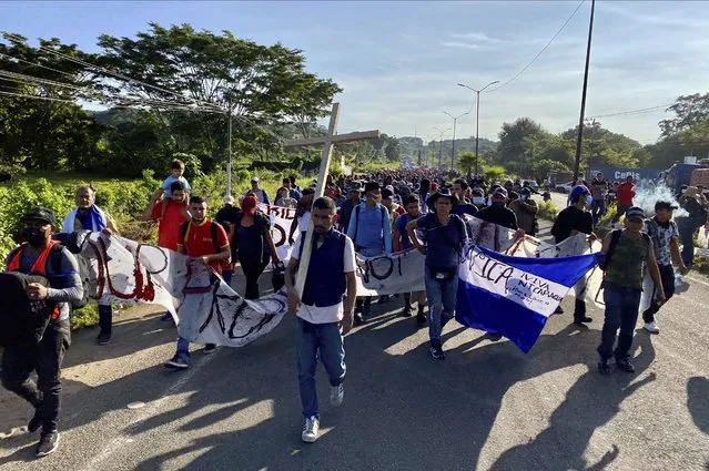 A caravan of migrants, most from central America, head north as they depart from Tapachula, Mexico, Saturday, October 23, 2021. Immigration activists say they will lead migrants out of the southern Mexico city of Tapachula Saturday at the start of a march they hope will bring them to Mexico City to press their case for better treatment. (Photo by Edgar H. Clemente/AP Photo)