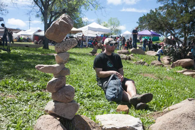 David Allen of Maine relaxes after stacking his rocks in a heavy traffic area of the festival, Saturday March 12, 2016. Allen has been creating environmental public art installations for about 20 years. (Photo by Nell Carroll/American-Statesman)
