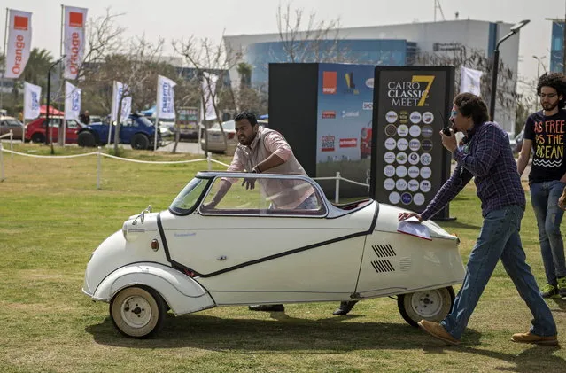 Two men push a classic Messerschmidt KR200 “Kabinenroller” at the 7th Cairo Classic Meet in Cairo, Egypt, 23 March 2019. The exhibition for classic cars is held at the Smart Village in Cairo. The exhibition is held to exchange experiences in how to preserve the old cars, and also for promoting tourism. (Photo by Mohamed Hossam/EPA/EFE)