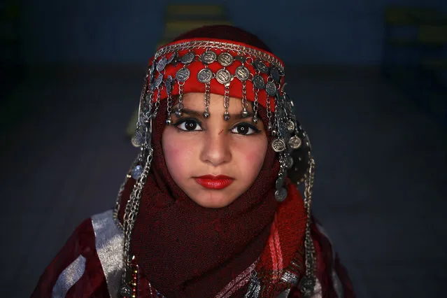 A girl wearing traditional costume poses for a picture during Children's Day celebrations, at a school in Benghazi, Libya March 21, 2016. (Photo by Esam Omran Al-Fetori/Reuters)