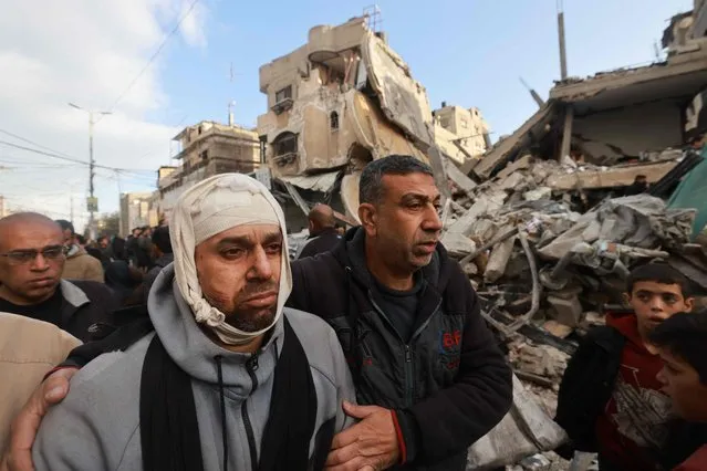 Wounded Palestinian Nidal al-Gharib, who lost his wife and daughter, walks past his neighbours' house destroyed by Israeli bombing in Rafah in the southern Gaza Strip on March 4, 2024, amid the ongoing conflict between Israel and the Palestinian militant group Hamas. (Photo by Mohammed Abed/AFP Photo)