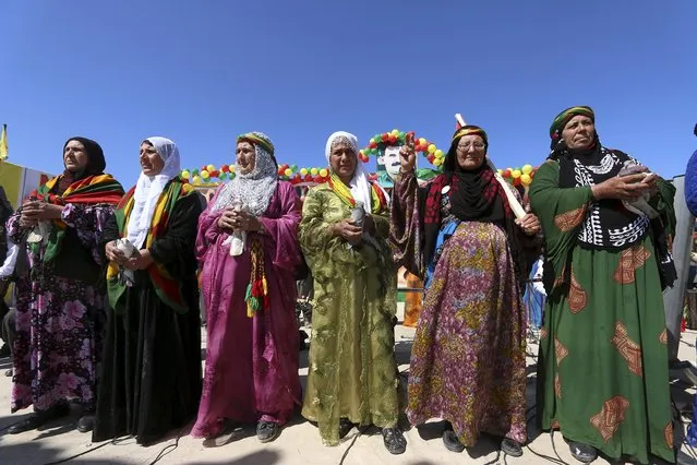 Mothers of Kurdish female fighters from the People's Protection Units (YPG) wear traditional dresses as they dance during a gathering to celebrate the spring festival of Newroz in the northeast Syrian Kurdish city of Qamishli, Syria March 21, 2016. (Photo by Rodi Said/Reuters)