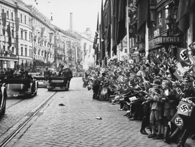Jubilant crowd cheering Hitler and Mussolini upon arrival in Munich on September 29, 1938. (Photo by AP Photo)