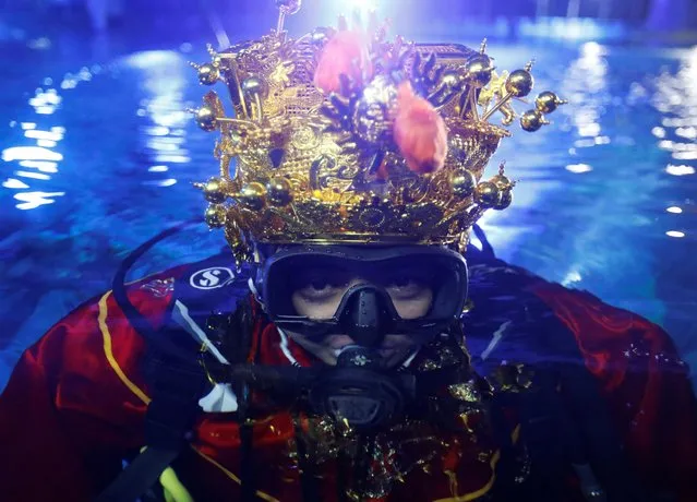 Diver Muhammed Nizamubbin Azman poses for a picture before his underwater performance as God of Prosperity inside an oceanarium of Aquaria KLCC in Kuala Lumpur, Malaysia on January 18, 2023. (Photo by Hasnoor Hussain/Reuters)
