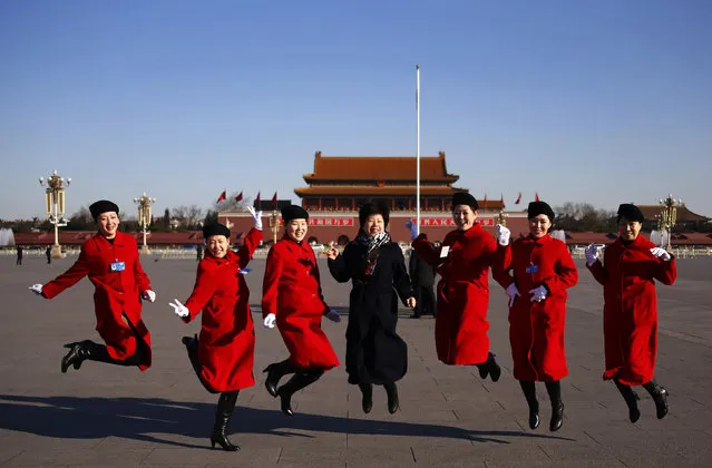 Hotel guides pose for pictures outside the Great Hall of the People at Tiananmen Square ahead of the opening session of the National People's Congress (NPC) in Beijing March 5, 2014. (Photo by Petar Kujundzic/Reuters)
