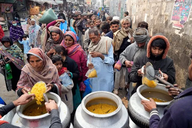 Pakistani people receive free food outside of Data Darbar shrine in Lahore, Pakistan, Saturday, February 10, 2024. (Photo by K.M. Chaudary/AP Photo)