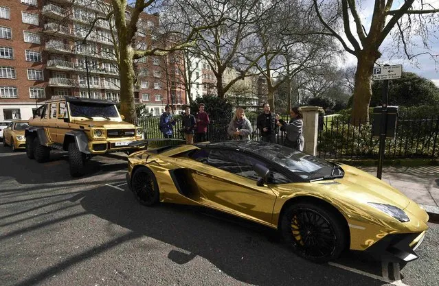 Performance cars with a gold wrap finish are seen parked in a street in Knightsbridge in London, Britain March 31, 2016. (Photo by Toby Melville/Reuters)
