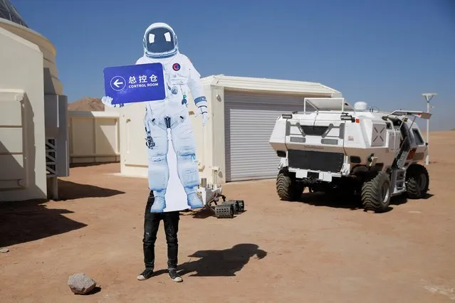 A staff member sets up a sign in the shape of a space suit at the C-Space Project Mars simulation base in the Gobi Desert outside Jinchang, Gansu Province, China, April 17, 2019. Apart from being a tourist attraction, the camp has collaborated with the Astronauts Center of China (ACC) to eventually turn the facility into an astronaut-training center. (Photo by Thomas Peter/Reuters)