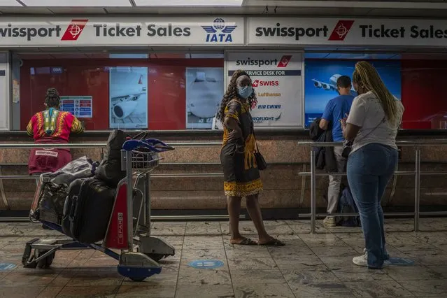 Passengers wait at a ticket counter at Johannesburg's OR Tambo's airport, Monday November 29, 2021. A pandemic-weary world faces weeks of confusing uncertainty as countries restrict travel and take other steps to halt the newest potentially risky coronavirus mutant before anyone knows just how dangerous omicron really is. (Photo by Jerome Delay/AP Photo/File)