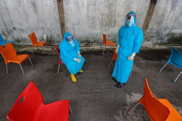 Health workers take a break from performing COVID-19 swab tests at a makeshift testing facility in Colombo, Sri Lanka, 13 December 2021. The country reported its first case of heavily-mutated coronavirus Omicron variant of concern on 03 December in a Sri Lankan National returning from South Africa. (Photo by Chamila Karunarathne/EPA/EFE)